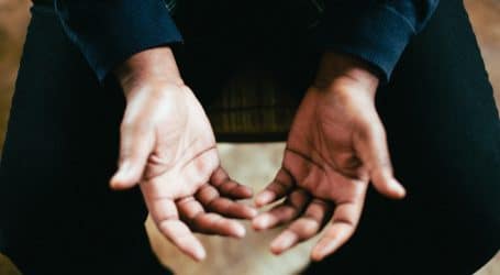 person showing both palms while sitting on chair