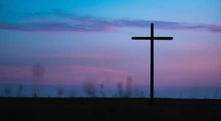 cross stand under purple and blue sky