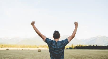 man reaching hands up high taken at daytime