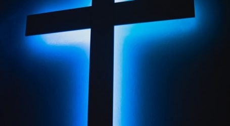 brown wooden cross on orange background