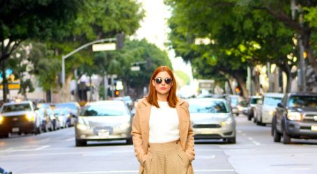 woman in brown dress standing on sidewalk during daytime