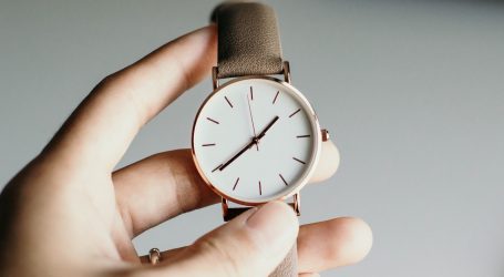 person holding analog watch