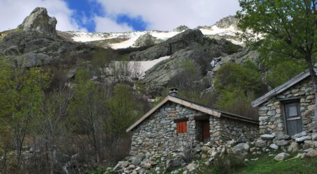 a small stone building sitting on top of a lush green hillside