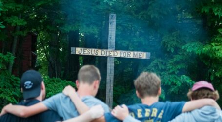 A group of people standing around a cross