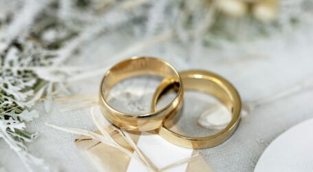 gold wedding band on white textile